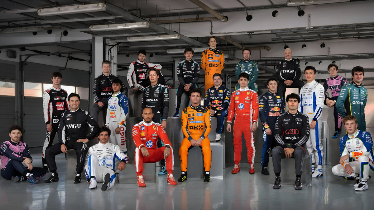 2026 F1 drivers wearing official Formula 1 race suits in a group team photo, featuring McLaren, Ferrari, Red Bull, Mercedes, Aston Martin, Alpine, Williams, Haas, Audi and other 2026 F1 teams.