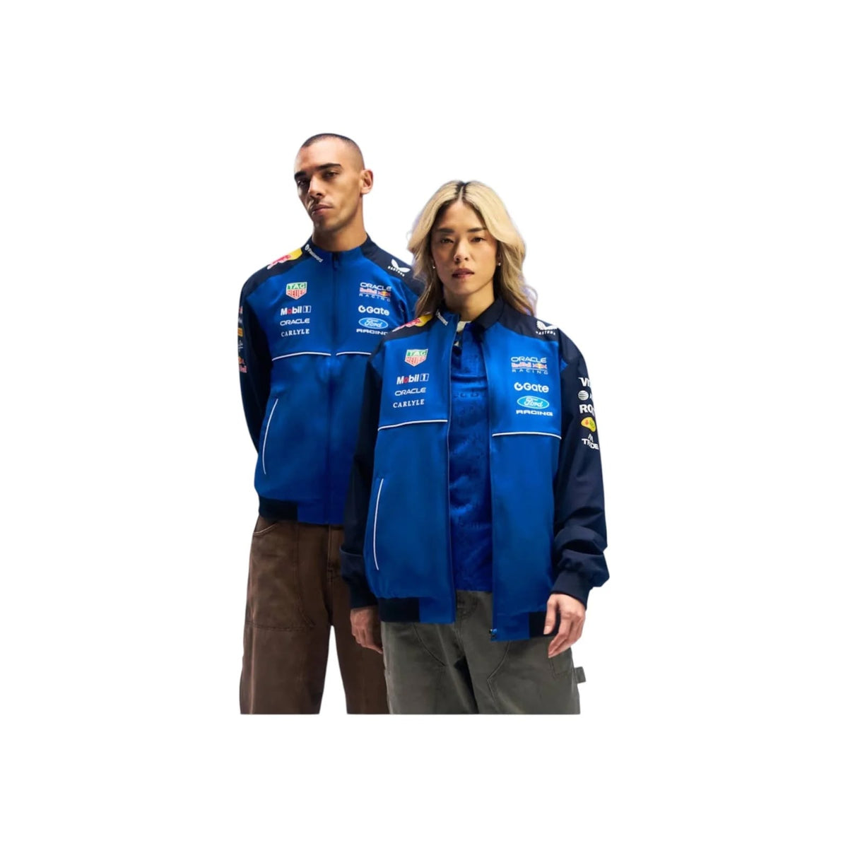 Two models wearing matching 2026 Red Bull Racing F1 Teamwear Bomber Jackets with sponsor logos, set against a plain white background.