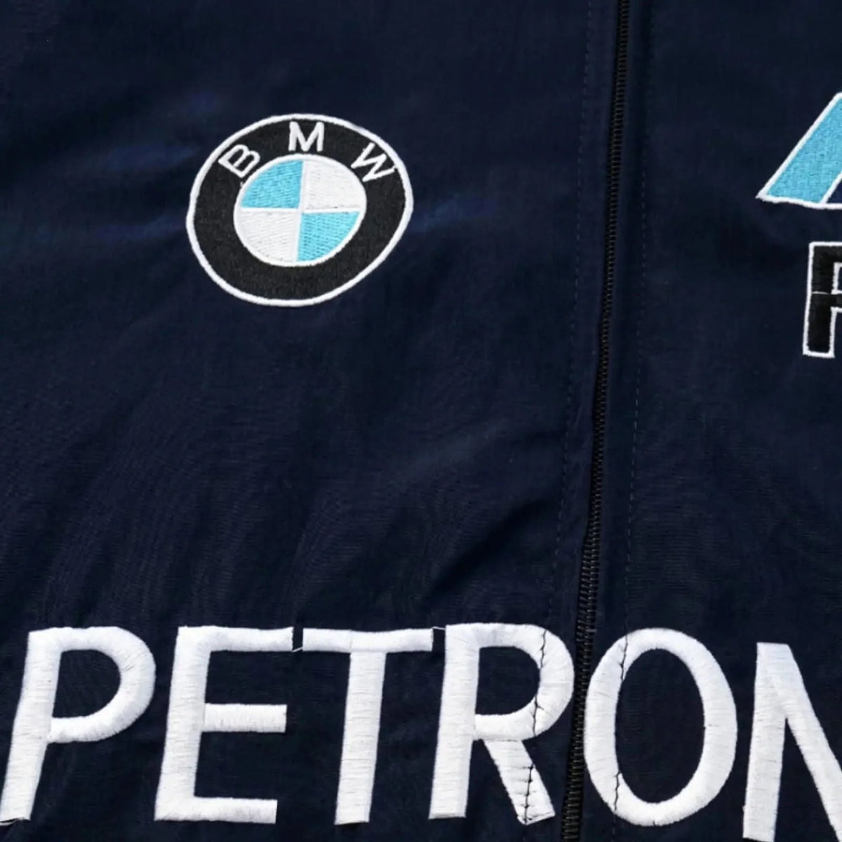 Navy jacket with BMW logo and 'PETRONAS' text on a dark background