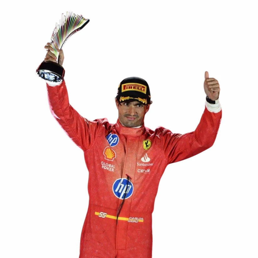Carlos Sainz in Ferrari 2024 Las Vegas GP F1 Racing Suit holding a trophy and giving a thumbs-up on a white background