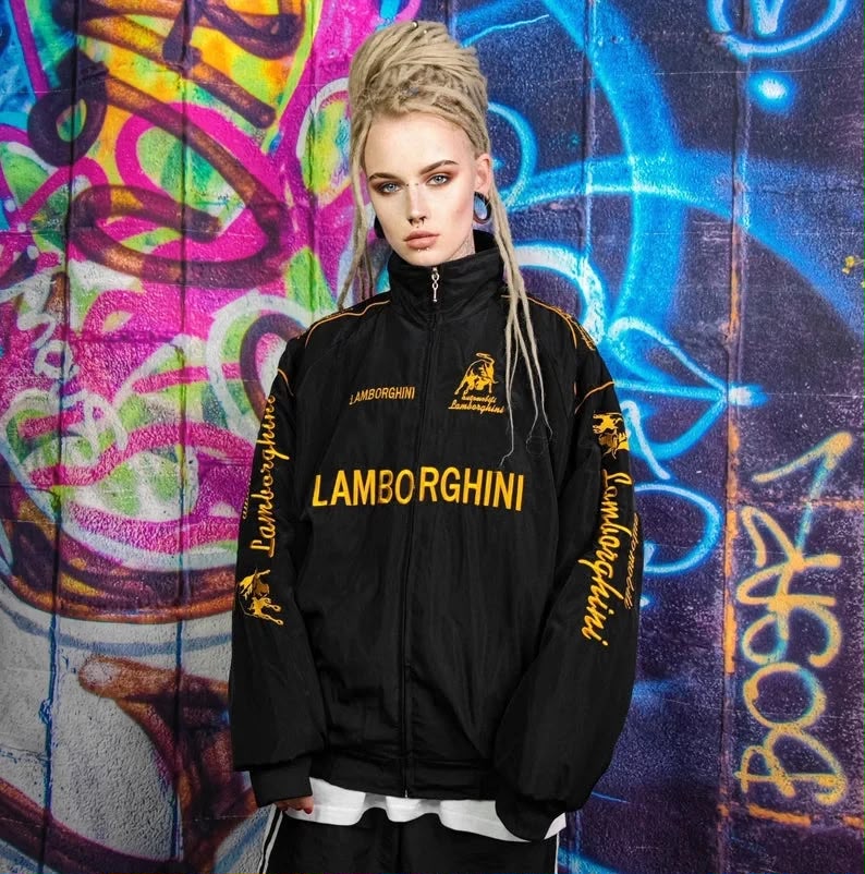 Person wearing Lamborghini Formula 1 Style Racing Jacket in front of a colorful graffiti wall