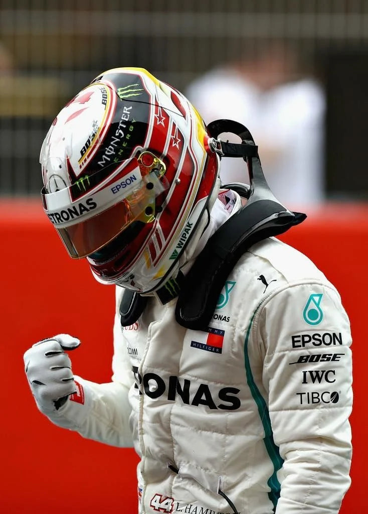 Lewis Hamilton in Mercedes 2018 F1 Racing Suit and helmet with visible branding on a red background