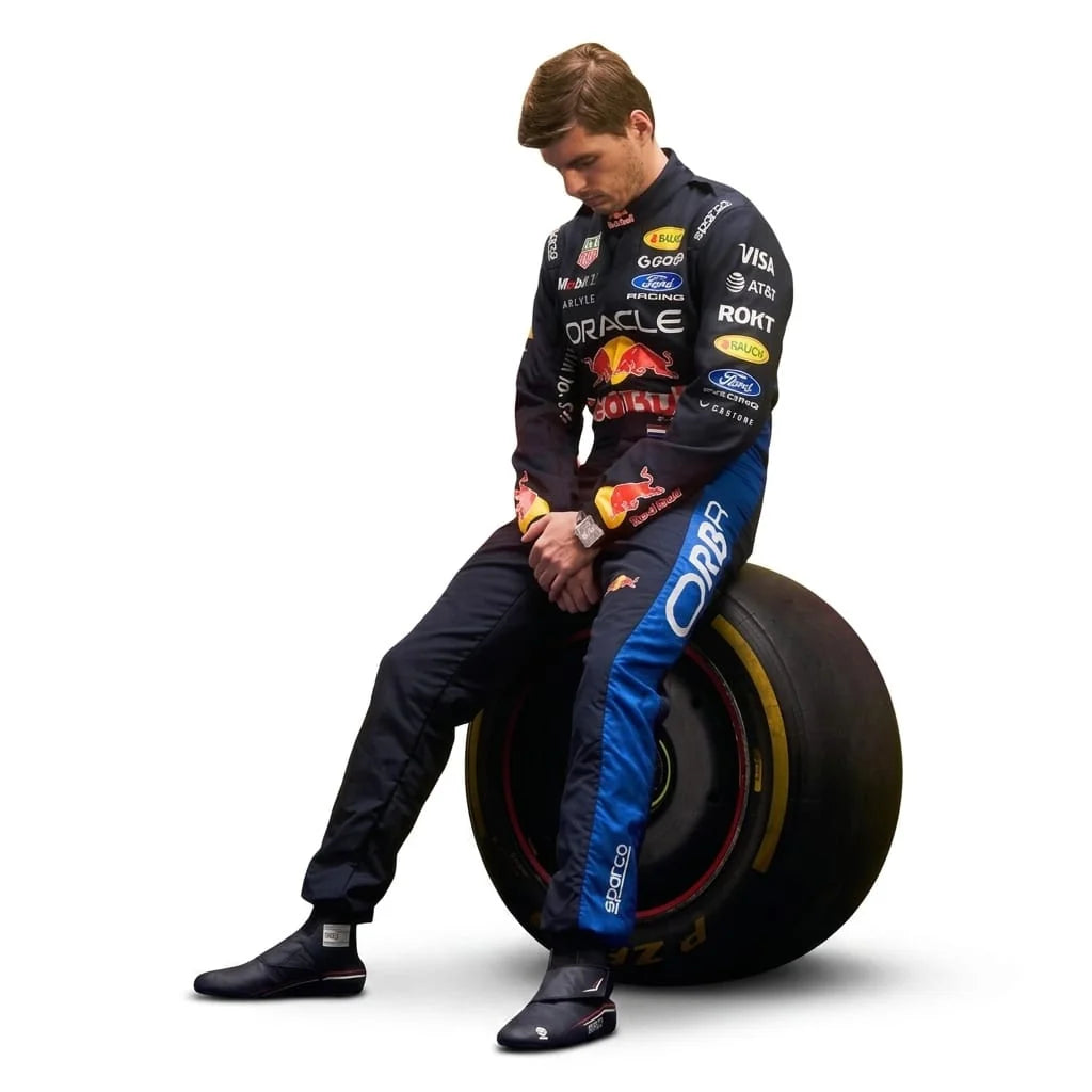 Max Verstappen Red Bull F1 racing suit 2026 sitting pose on Pirelli F1 tyre