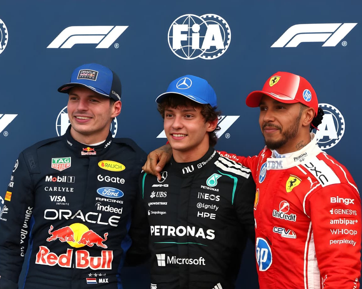 Three Formula 1 drivers standing together with FIA and F1 logos in the background