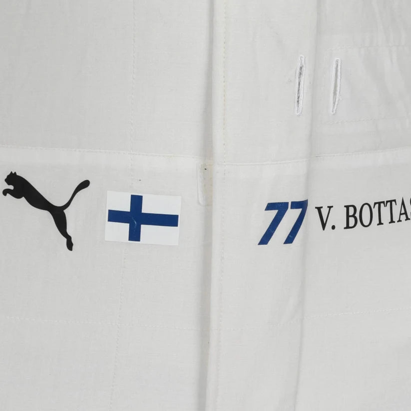 Close-up of a white jacket with Puma logo, Finnish flag, and text on a light gray background