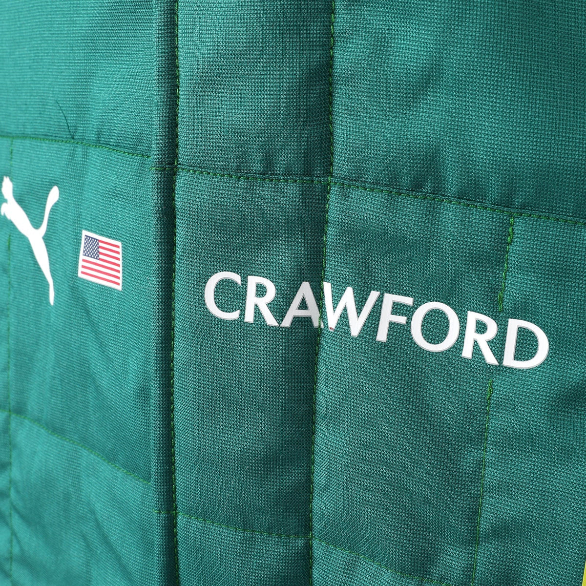 Crawford name and United States flag detail on the 2026 Aston Martin F1 race suit – Reaxion Racegear.